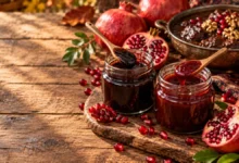 فرق رب انار ملس و ترش؛ دو شیشه رب انار در کنار انار تازه